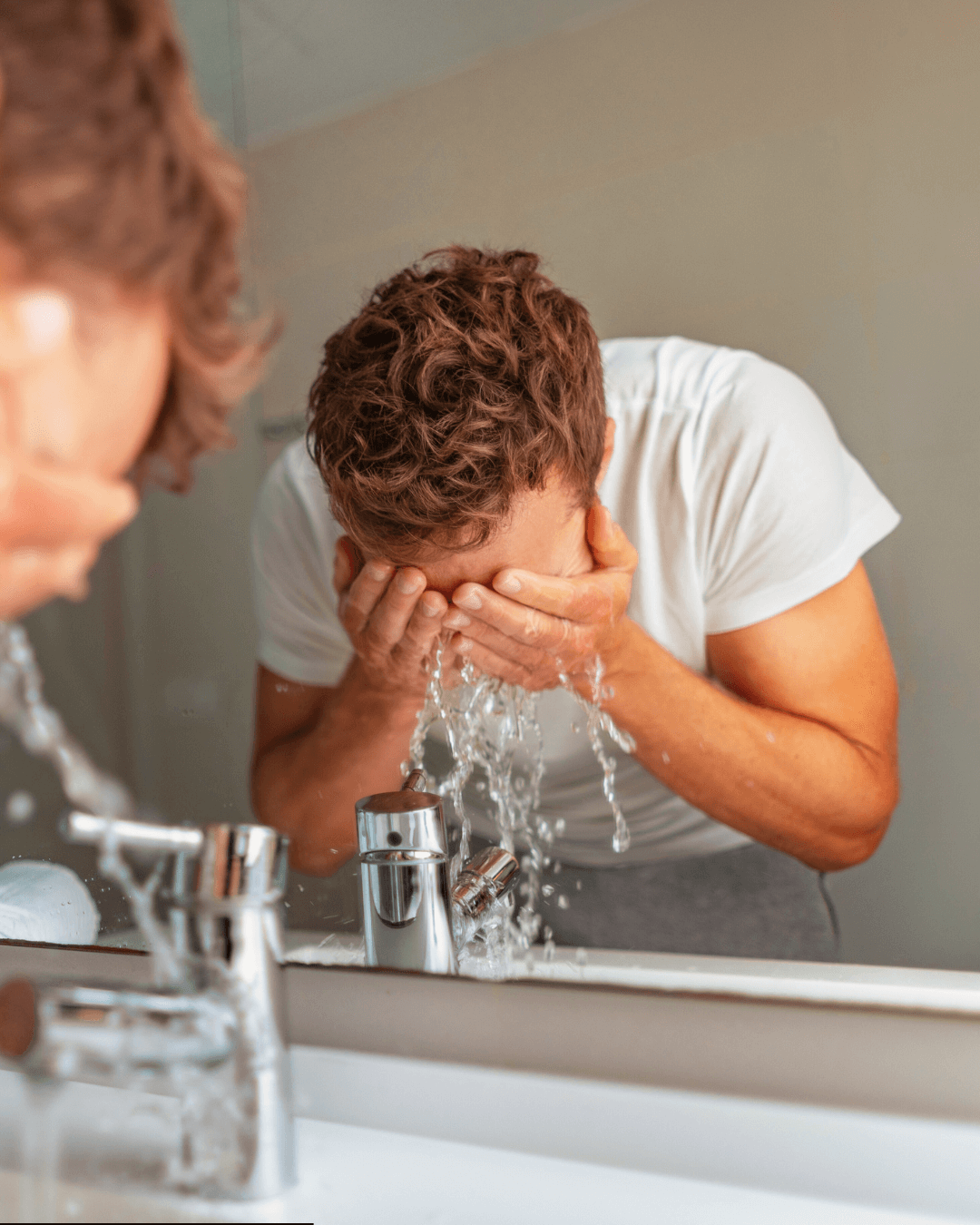 A person cleansing their face to illustrate the importance of a skincare routine